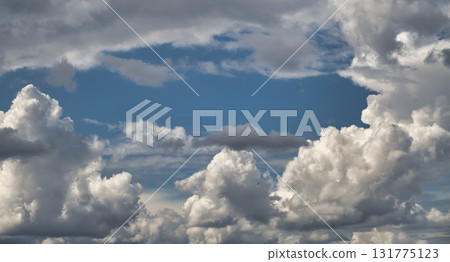 Puffy white clouds against a bright blue sky create a beautiful scene. Puffy white clouds against a bright blue sky create a beautiful scene. 131775123
