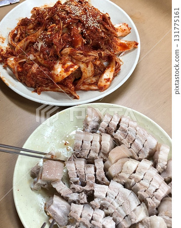 Suyuk, a traditional Korean dish of boiled pork slices, tender and juicy, often served with salted shrimp sauce, garlic, and ssamjang. Perfect for wrapping in lettuce for a flavorful, balanced bite. 131775161