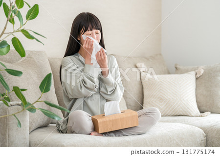 亞洲年輕女性在沙發上看電視或電影時擦眼淚 131775174