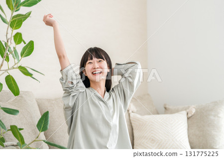 Young Asian woman relaxing and refreshing on the sofa at home (morning routine) 131775225