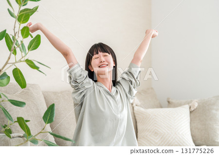 Young Asian woman relaxing and refreshing on the sofa at home (morning routine) 131775226