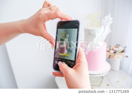 A woman is taking a picture of a cake with the words "MISS" on it A woman is taking a picture of a cake with the words "MISS" on it 131775269