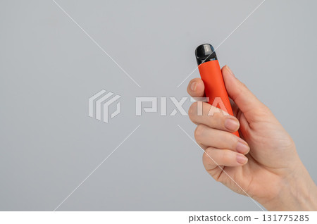 Woman holding disposable vape on white background. Copy space. Woman holding disposable vape on white background. Copy space. 131775285
