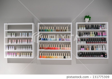 A wall of shelves with many bottles of nail polish A wall of shelves with many bottles of nail polish 131775309
