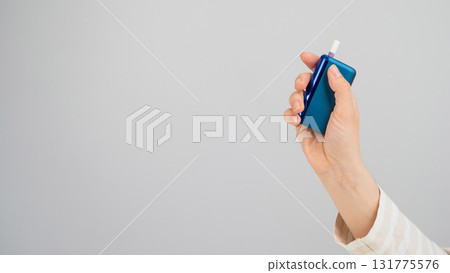 Woman holding electronic cigarette on white background. Tobacco heating systems. 131775576