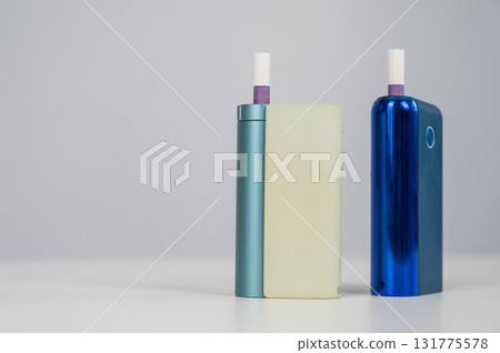 Two electronic cigarettes on a white background. Tobacco heating systems. Two electronic cigarettes on a white background. Tobacco heating systems. 131775578