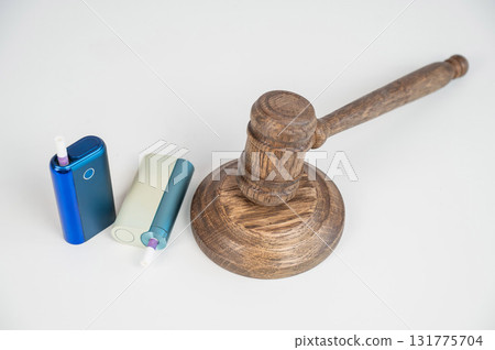Judge's gavel and electronic cigarette. Smoking ban. Tobacco heating systems.  131775704