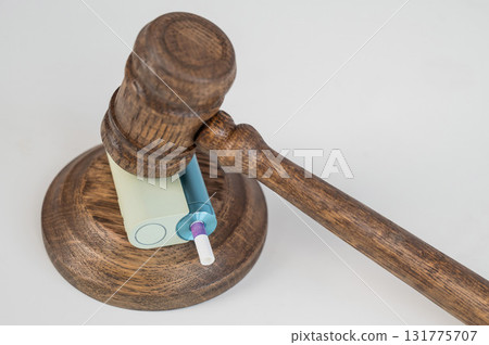 Judge's gavel hits e-cigarette. Smoking ban. Tobacco heating systems. Judge's gavel hits e-cigarette. Smoking ban. Tobacco heating systems. 131775707