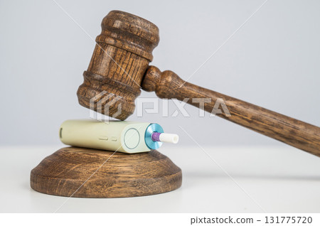 Judge's gavel hits e-cigarette. Smoking ban. Tobacco heating systems. Judge's gavel hits e-cigarette. Smoking ban. Tobacco heating systems. 131775720