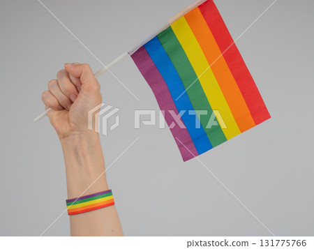 A woman holds a rainbow flag in her fist. A symbol of the fight for equality. 131775766