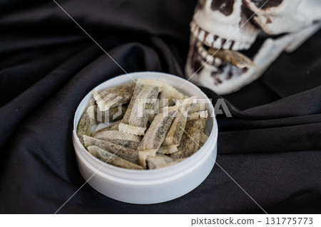 Skull Chewing Tobacco on Black Cloth. Skull Chewing Tobacco on Black Cloth. 131775773