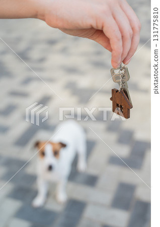 Woman holding bunch of house keys with dog in background.  131775810