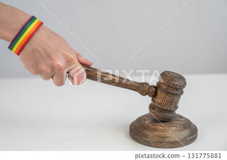 Judge hits gavel on rainbow bracelet.  131775881
