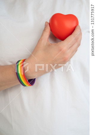 Caucasian woman with rainbow bracelet holding heart. Caucasian woman with rainbow bracelet holding heart. 131775917