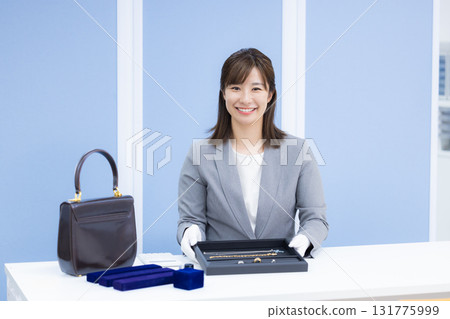 一位女士在採購公司的櫃檯評估一件商品 131775999