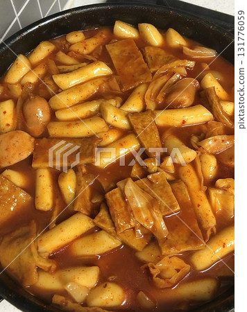 Spicy Korean tteokbokki with chewy rice cakes in a vibrant red sauce, topped with sesame seeds and green onions. A popular street food known for its addictive flavor and satisfying texture. Spicy Korean tteokbokki with chewy rice cakes in a vibrant red sauce, topped with sesame seeds and green onions. A popular street food known for its addictive flavor and satisfying texture. 131776059