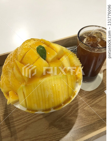 Refreshing mango bingsu with fluffy shaved ice, sweet mango chunks, and creamy condensed milk. A perfect Korean dessert for hot days, offering a delightful balance of fruity and creamy flavors! 131776096