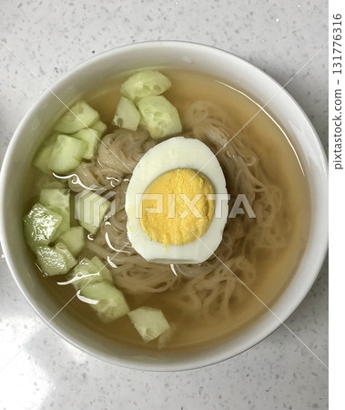 Authentic Pyongyang naengmyeon with chewy buckwheat noodles in cold, clear broth, offering a refreshing and delicate flavor. Perfect for traditional Korean cuisine menus and summer dishes. 131776316