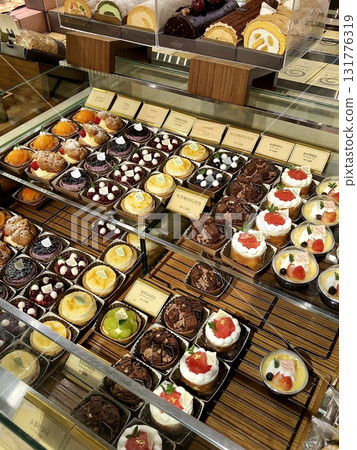 A delightful assortment of desserts displayed in a cozy cafe setting, featuring cakes, pastries, and sweet treats on elegant plates, creating a warm and inviting atmosphere. A delightful assortment of desserts displayed in a cozy cafe setting, featuring cakes, pastries, and sweet treats on elegant plates, creating a warm and inviting atmosphere. 131776319