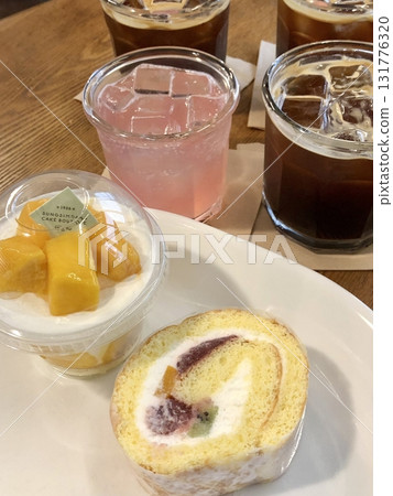 A delightful assortment of desserts displayed in a cozy cafe setting, featuring cakes, pastries, and sweet treats on elegant plates, creating a warm and inviting atmosphere. 131776320