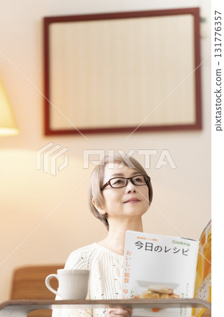 一位老年婦女在客廳看食譜書 一位老年婦女在客廳看食譜書 131776357