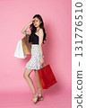 Young Asian Woman looking at camera while holding shopping bags on pink background 131776510