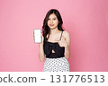 Cheerful smiling Asian woman holding smartphone isolated on pink background.with clipping path 131776513