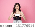 Cheerful smiling Asian woman holding smartphone isolated on pink background.with clipping path 131776514