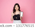 Cheerful smiling Asian woman holding smartphone isolated on pink background.with clipping path 131776515