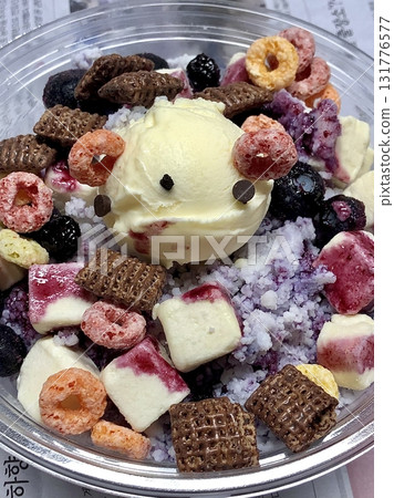 Swirled yogurt ice cream dessert served in a cup, smooth creamy texture with glossy surface, topped with fresh fruit pieces, highlighting its refreshing and inviting appearance in detail 131776577