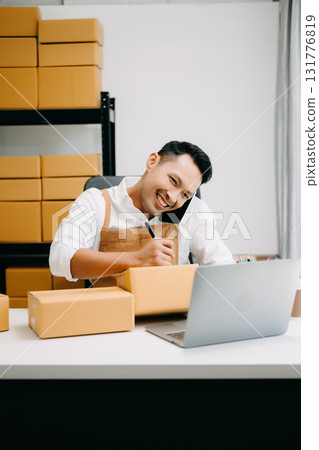 Portrait of Asian man SME working using smartphone or tablet taking receive and checking online purchase shopping order to ,freelance business online concept. Portrait of Asian man SME working using smartphone or tablet taking receive and checking online purchase shopping order to ,freelance business online concept. 131776819
