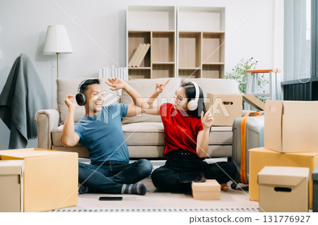Young couple with big boxes moving into a new house, new apartment for couple, young asian man and woman helping to lift boxes on sofa for the new home Young couple with big boxes moving into a new house, new apartment for couple, young asian man and woman helping to lift boxes on sofa for the new home 131776927