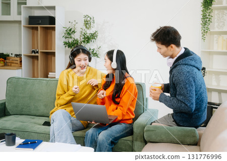 vibrant teamwork, creativity, and learning with young adults using laptops and headphones  in cozy 131776996