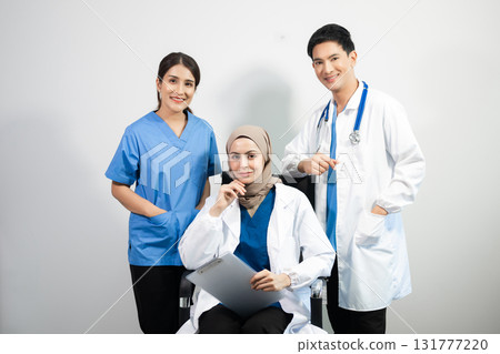 Successful team of medical doctors looking at camera and smiling while standin. Health, professional and people team Successful team of medical doctors looking at camera and smiling while standin. Health, professional and people team 131777220