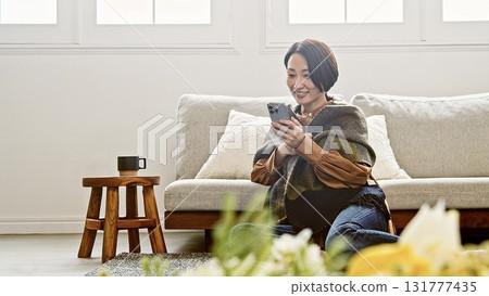 Woman operating a mobile phone Woman operating a mobile phone 131777435