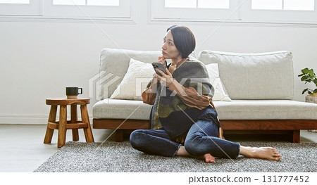 Woman operating a mobile phone Woman operating a mobile phone 131777452