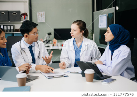 Medical, meeting and laptop for team in discussion, brainstorming and planning. Doctor, nurse on desk show diversity in collaboration, teamwork or workshop in hospital 131777576