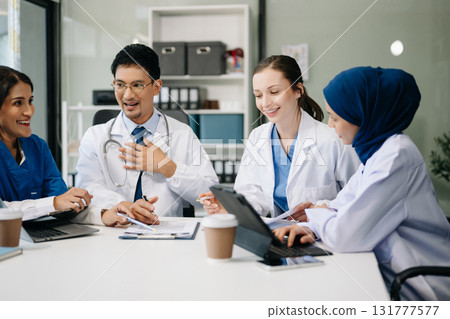 Medical, meeting and laptop for team in discussion, brainstorming and planning. Doctor, nurse on desk show diversity in collaboration, teamwork or workshop in hospital 131777577