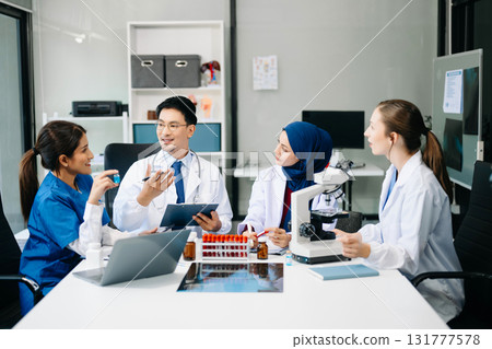 Doctor Talks With Professional Head Nurse or Surgeon, They Use Digital tablet Computer. Diverse Team of Health Care Specialists Discussing Test Result on desk 131777578