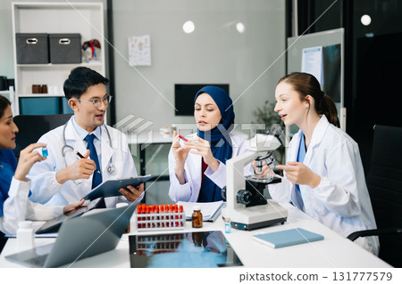 Doctor Talks With Professional Head Nurse or Surgeon, They Use Digital tablet Computer. Diverse Team of Health Care Specialists Discussing Test Result on desk 131777579
