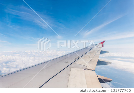 View from the airplane window at a beautiful cloudy sky and the airplane wing 131777760