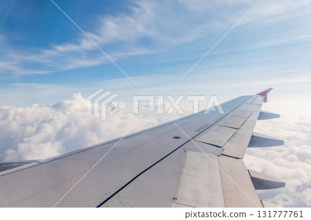 View from the airplane window at a beautiful cloudy sky and the airplane wing 131777761