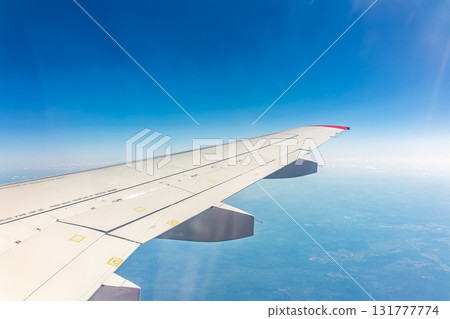 View from the airplane window at a beautiful blue clear sky and the airplane wing 131777774