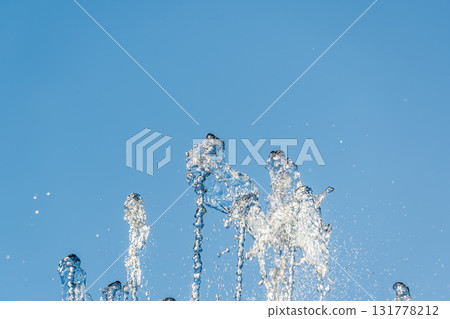 Splashes and jets of water against light background. Splashes and jets of water against light background. 131778212