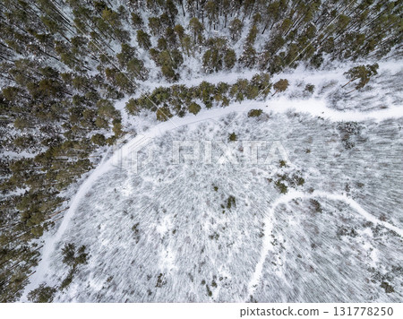 Aerial view of a winter pine forest. Top view of snow-covered pine trees. Beautiful winter forest landscape. Aerial view of a winter pine forest. Top view of snow-covered pine trees. Beautiful winter forest landscape. 131778250