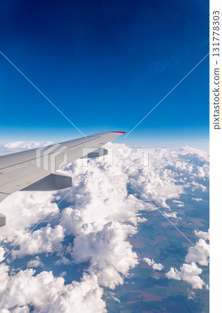 View from the airplane window at a beautiful cloudy sky and the airplane wing View from the airplane window at a beautiful cloudy sky and the airplane wing 131778303