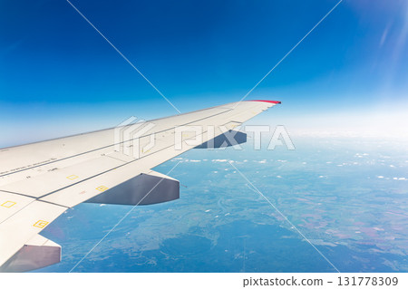 View from the airplane window at a beautiful blue clear sky and the airplane wing View from the airplane window at a beautiful blue clear sky and the airplane wing 131778309
