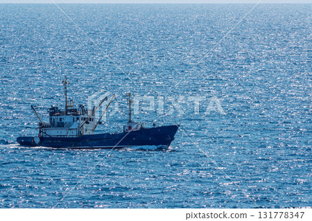 Fishing boat in blue sea and clear sky with birds flying overhead. Fishing boat in blue sea and clear sky with birds flying overhead. 131778347