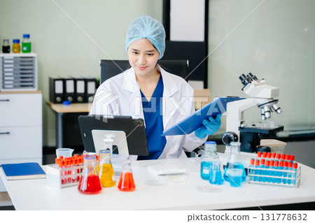 female scientist working with micro pipettes analyzing biochemical 131778632