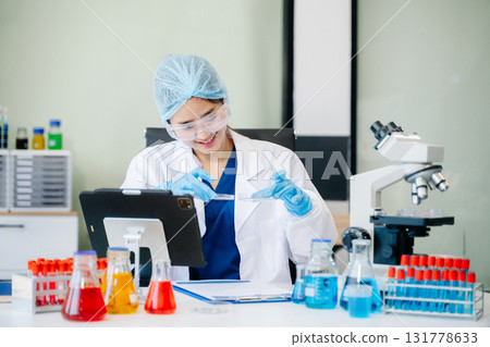 female scientist working with micro pipettes analyzing biochemical 131778633